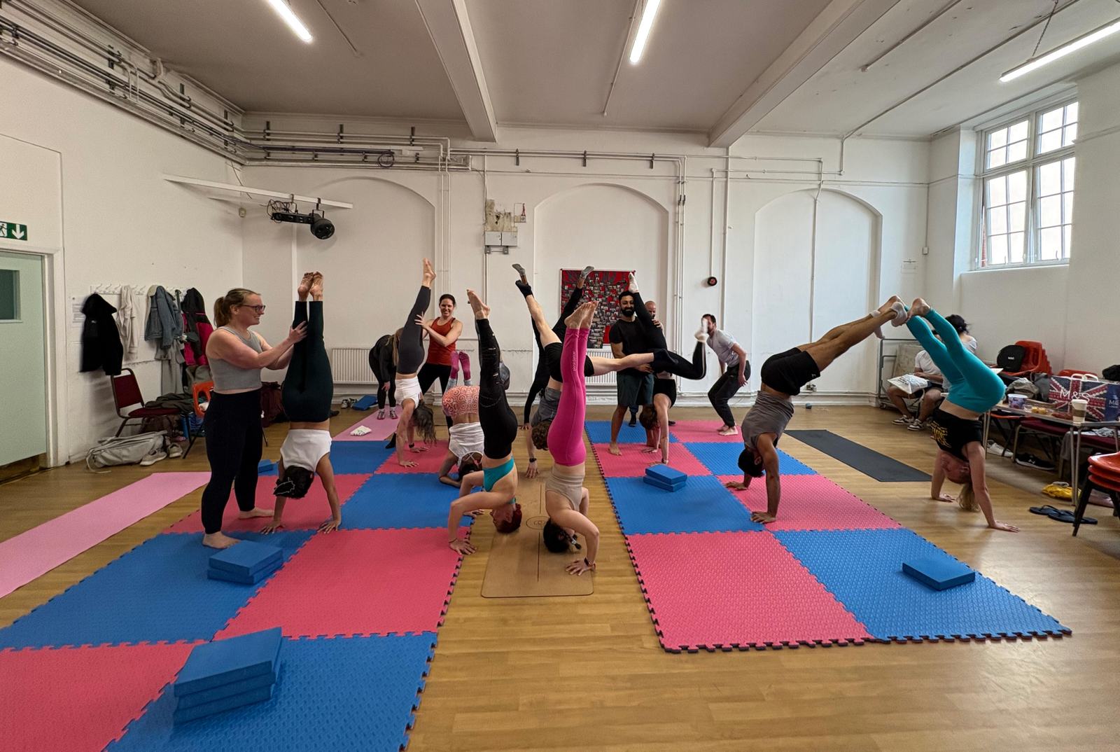 A full room at a class, coaches spotting people upside down